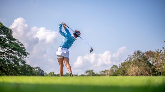 Professional woman golfer teeing golf in golf tournament competition at golf course for winner	