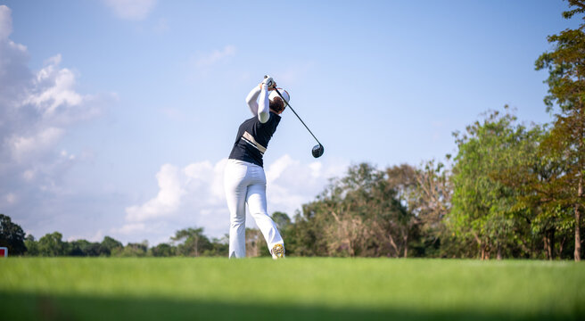 Professional woman golfer teeing golf in golf tournament competition at golf course for winner	