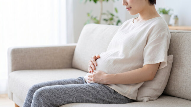 お腹を優しく撫でる妊婦の女性