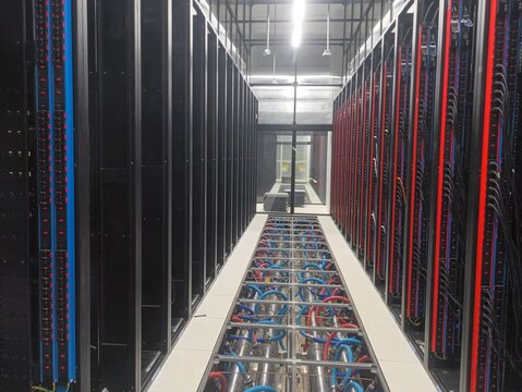 Modern data center server room aisle with PDU racks and exposed underfloor liquid cooling system infrastructure for AI server computing.