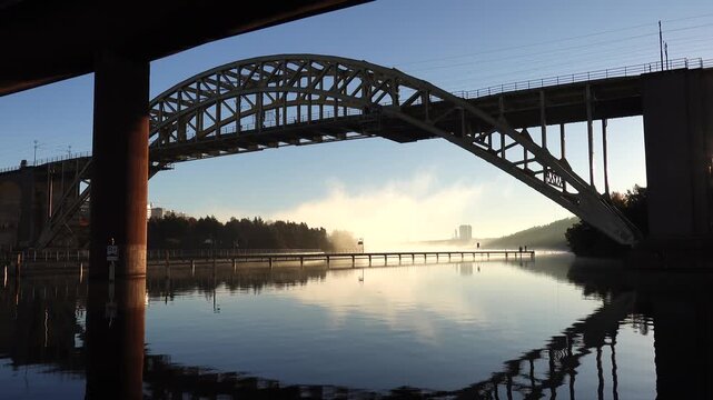 Stockholm, Sweden A view of Arstaviken Bay and the Arsta train bridge on a cold and misty autumn morning, and the STHLM 01 tower in the distance. 