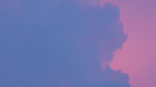 Blue cumulus cloud against a vivid pink and purple sunset sky, dreamy surreal pastel gradient cloudscape with soft glowing light