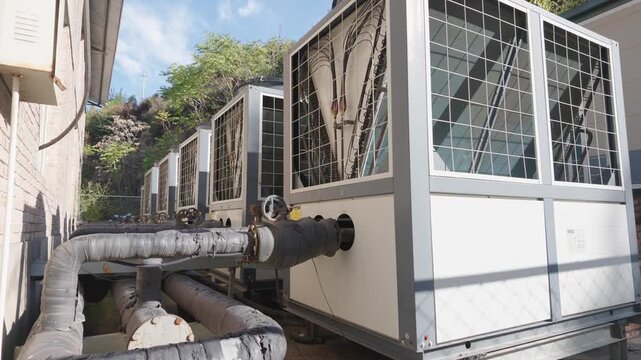 Industrial cooling system, air conditioner, ventilation duct, machinery, pipe, metal framework, protective grille, building exterior, infrastructure engineering, outdoor equipment room beside