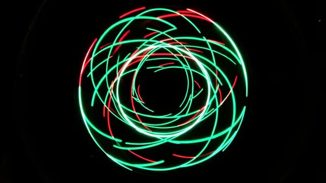 Abstract neon light trails rotate and overlap into a glowing spherical form against black, creating a dynamic futuristic motion graphics animation