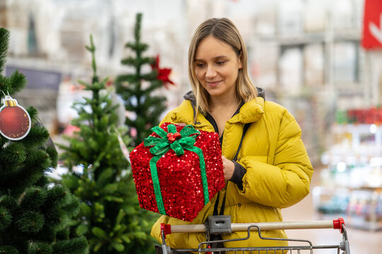 Close up of happy smiling woman with Christmas gift box with red ribbon in her hands
