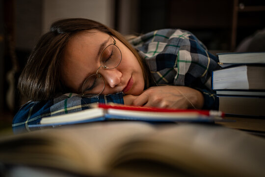 Woman, book and student on bed for nap with sleeping for study break, academic knowledge and tired. Frustrated girl, notebook and home in bedroom for tuition loan with school debt and depression