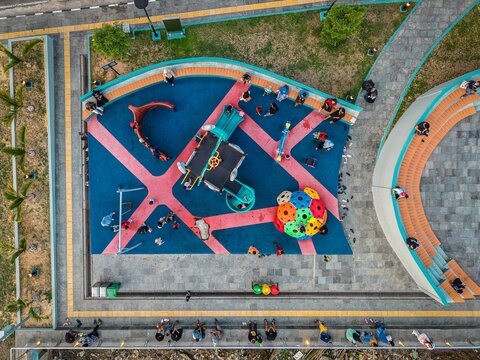 Aerial view of Teras Samarinda 2 playground with colorful rubber flooring, play structures, and people enjoying the park in Samarinda, East Kalimantan, Indonesia.