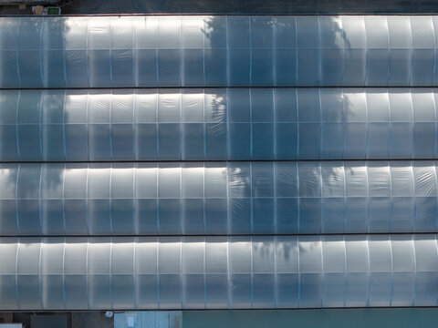 Aerial view of the Plant Growers Australia Pty Ltd greenhouse facility featuring rows of translucent arched roofs and tree shadows in Wonga Park, Victoria, Australia.