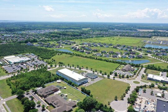 Aerial view of suburban residential neighborhoods, commercial buildings, green spaces, and small ponds in Virginia Beach, Virginia, United States.