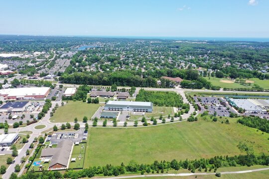 Aerial view of commercial buildings, parking lots, and green fields surrounded by residential neighborhoods in Virginia Beach, Virginia, United States.