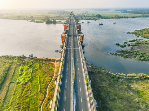 Aerial view of Kabanaran Bridge spanning a river, surrounded by lush green fields and rural landscape in Kecamatan Srandakan, Daerah Istimewa Yogya, Indonesia.