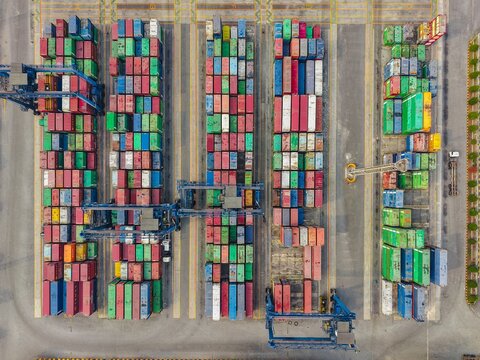 Aerial view of PT Pelabuhan Samudera Palaran, a busy container terminal with rows of colorful shipping containers, gantry cranes, and paved loading areas in Samarinda, East Kalimantan, Indonesia.