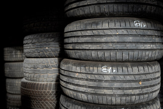 Stacked Used Car Tires with Worn Tread in Tire Storage