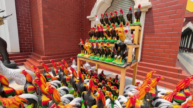 Colorful Rooster Statues Displayed as Traditional Offerings at Thai Shrine