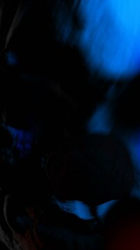 Creepy seamless vertical video of an horror clown mask with color strobe lights. Halloween background of a terror character with blood splashes.