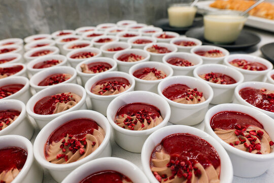 Portioned chocolate mousse desserts with raspberry sauce on a hotel buffet