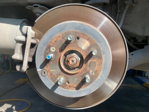 Car Brake Disc Close-up: A detailed close-up view of a car's brake disc and rotor assembly, showcasing the components of this essential automotive part, ready for maintenance or inspection.