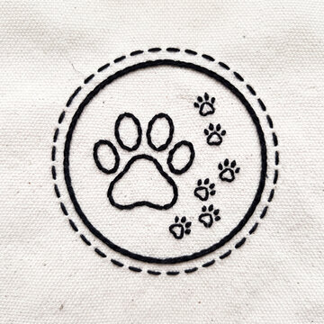 black thread embroidered dog paw print on canvas fabric