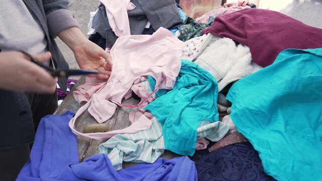 Woman Tearing Old Clothes for Textile Recycling