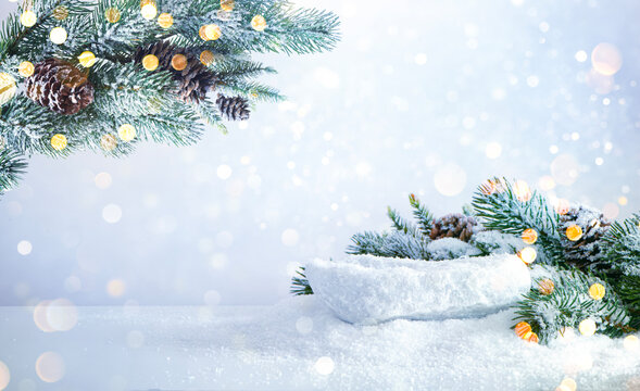 Winter background with snow covered pine branches and glowing abstract lights