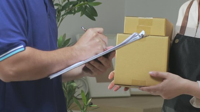 Delivery person handing over parcel to recipient, express courier receiving package, close-up of hands exchanging cardboard box