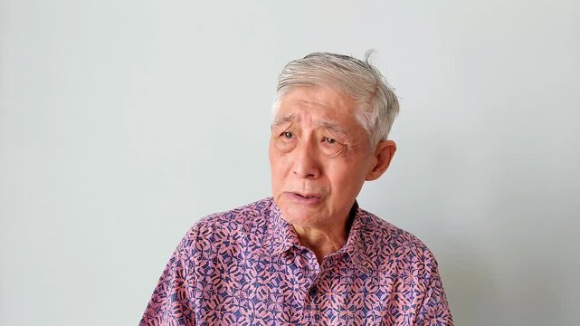 Old Asian Man Shaking His Head with Concerned and Disappointed Facial Expression