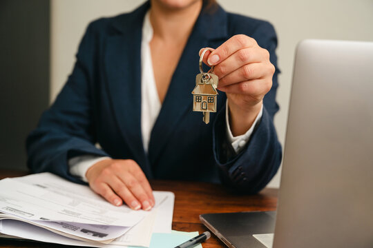 Real estate agent presenting house keys after property purchase