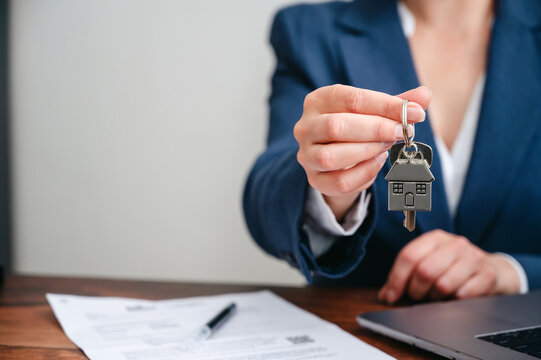 Real estate agent presenting house keys to new home owner