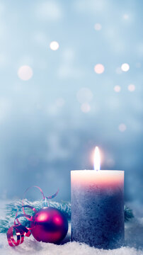 christmas background with burning candle and red bauble decoration in snow isolated on blue abstract winter backdrop, social media xmas greeting card with copy space