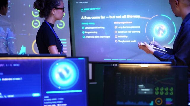 Latina engineer points at the AI capabilities chart on a glowing touchscreen as a Black colleague taps his tablet, the slides moving on to opportunities and challenges