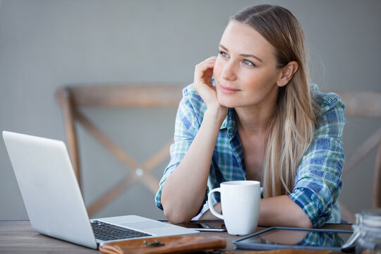 Young Woman Daydreaming During a Laptop Work Break