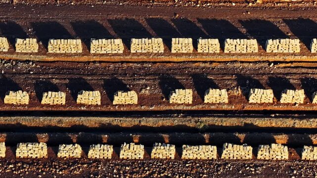 Aerial view of rows of stacked bricks casting long shadows on the ground in Jelgava, Latvia.