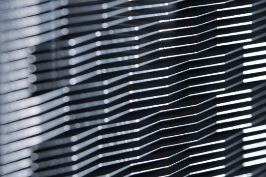 Abstract close up texture aluminum metallic radiator cooling fins with bokeh depth of field.