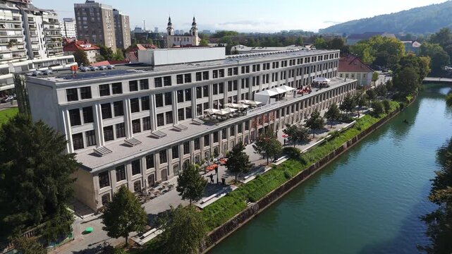 Ljubljana, Slovenia drone aerial of Center Rog creative hub beside Ljubljanica river, modern architecture, riverside walkways, green spaces and historic city surroundings.