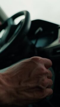 Driver's hands on car gearshift and steering wheel