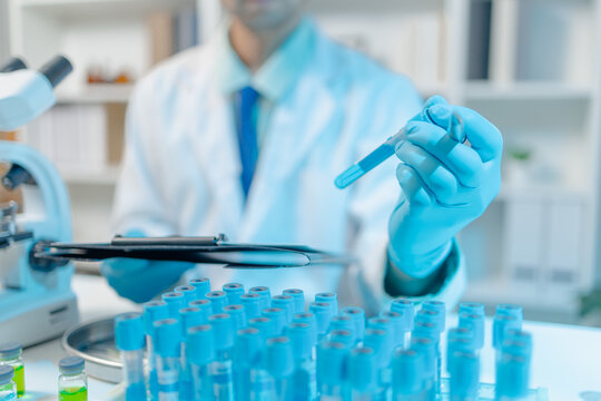 Scientist examining laboratory samples and test tubes for scientific research, analysis, and experimental studies in a modern laboratory.