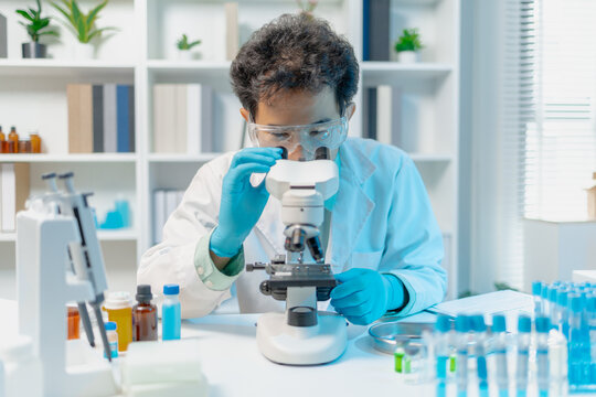 Scientist examining laboratory samples and test tubes for scientific research, analysis, and experimental studies in a modern laboratory.