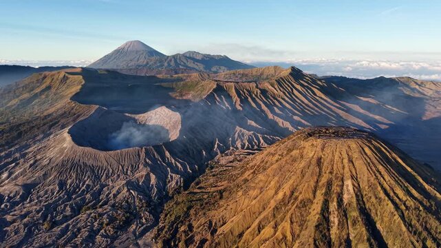 Morning light highlights volcanic crater, ridges, and smoky caldera landscape.