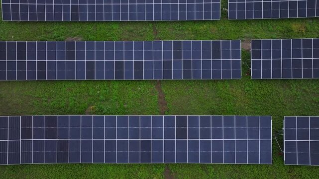 Aerial view of rows of solar panels installed on a green field in Ambrolauri, Racha-Lechkhumi and Lower Svaneti, Georgia.