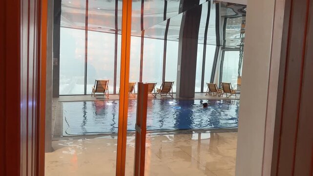 Spa center pool with calm water, soft lighting, relaxing atmosphere, tiles, loungers, wellness escape.