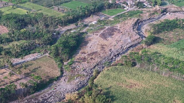 Aerial drone view of tropical plantation, riverbed, fields and rural village in Candipuro.
