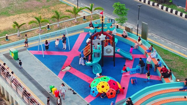 Aerial view of Teras Samarinda 2 playground with children playing on slides, swings, and climbing structures in the city park of Samarinda, East Kalimantan, Indonesia.