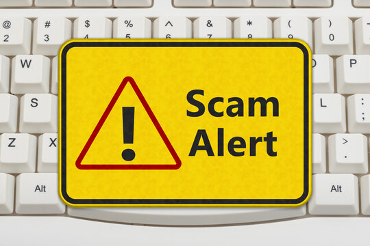 Scam Alert yellow warning sign on a keyboard