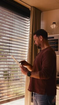 Side view of man using smart home app.