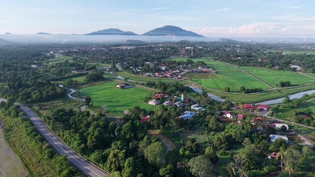 Aerial view of rural landscape with rice fields and distant mountains at Perai, Penang