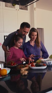Mom and daughter making breakfast in kitchen.