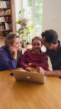 Parents and daughter booking holiday accommodation online.