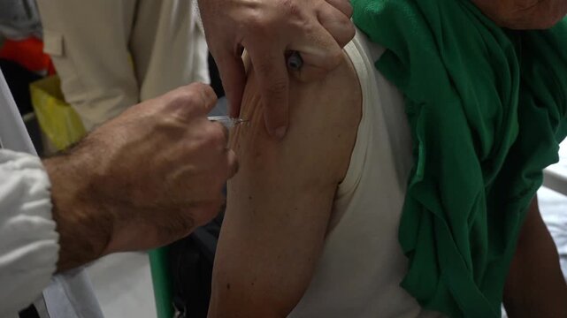 Italy, Milan &ndash; Vaccination campaign for the elderly population: flu vaccine, COVID-19 (coronavirus), and staphylococcus - hospital and doctor with vaccine injection syringe