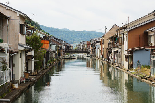 Quiet waterway lined with houses and small moored boats