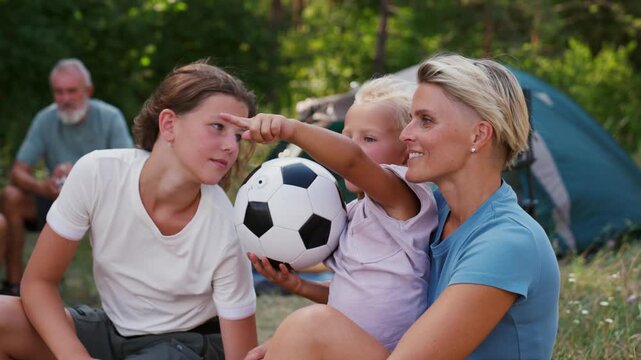 Family relaxing and spending time together at campsite.